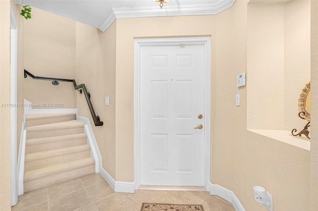 foyer entrance with baseboards, ornamental molding, light tile patterned floors, and stairway
