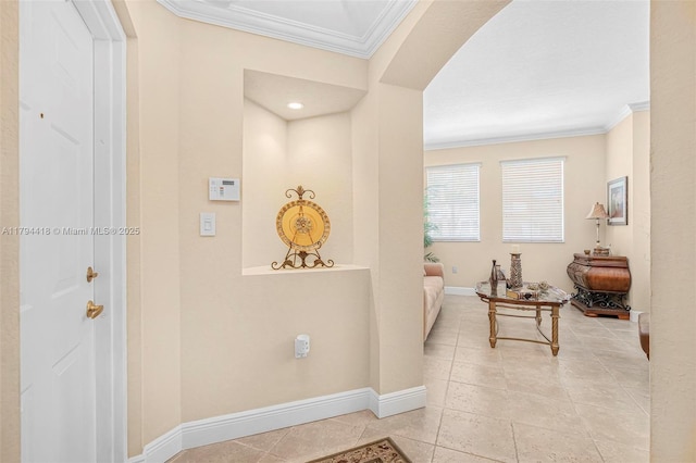corridor featuring crown molding, baseboards, and light tile patterned floors