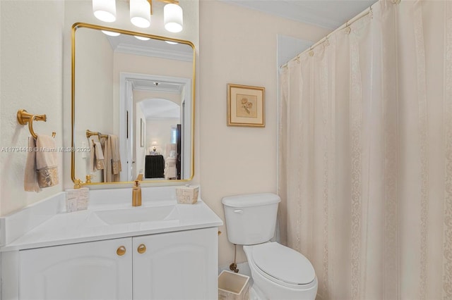 bathroom featuring toilet, ornamental molding, and vanity