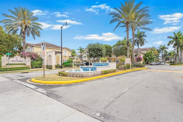 view of road with a residential view, street lighting, and curbs