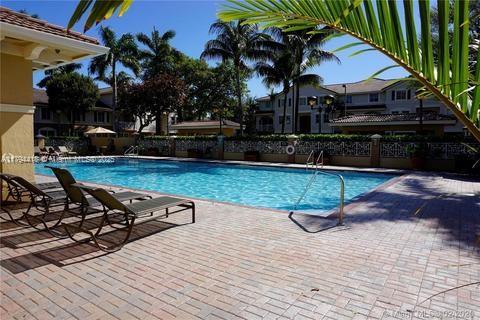 community pool with a patio area and fence