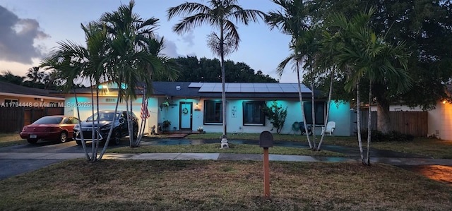 8111 SW 205th St, Cutler Bay, FL 33189 - ranch-style home featuring fence, driveway, solar panels, and a front lawn
