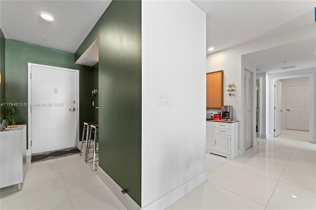 hall with recessed lighting, baseboards, light tile patterned floors, and visible vents
