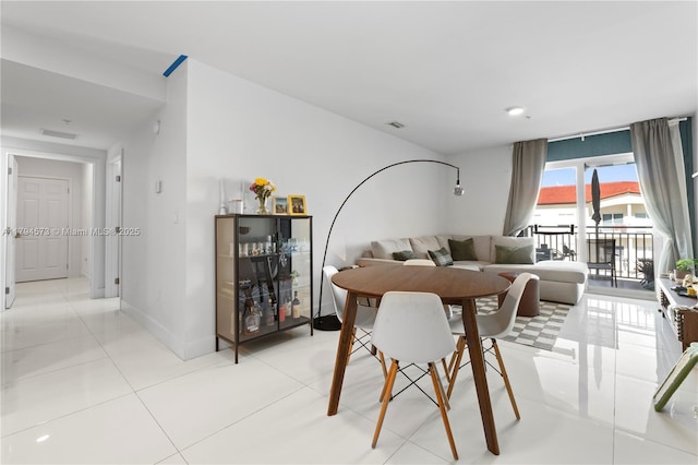 dining space with baseboards, visible vents, and light tile patterned floors