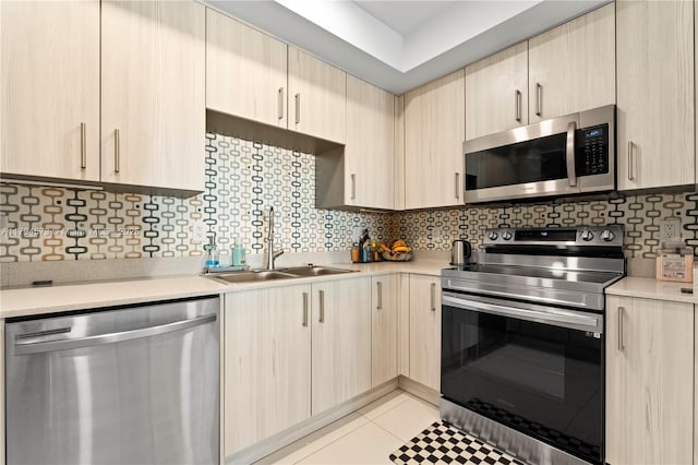 kitchen featuring a sink, appliances with stainless steel finishes, light brown cabinetry, and light countertops