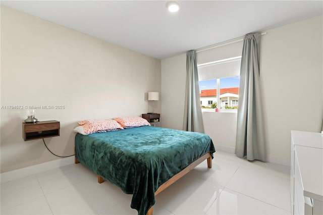 bedroom featuring light tile patterned floors and baseboards