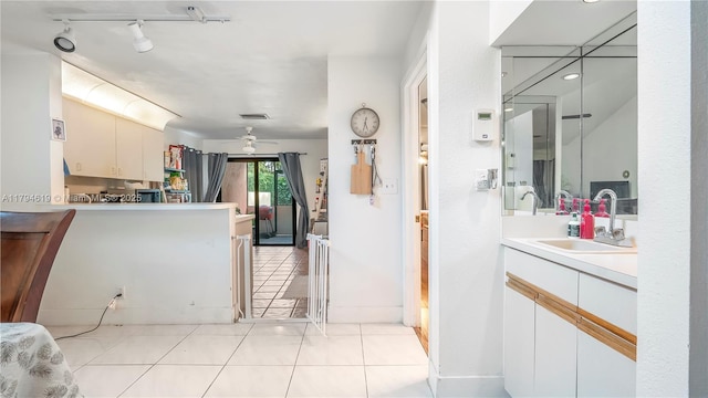 kitchen with track lighting, a ceiling fan, light tile patterned flooring, light countertops, and a sink