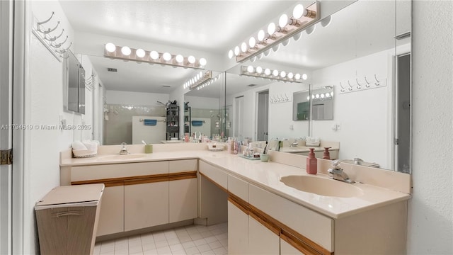 bathroom with double vanity, a sink, and a stall shower