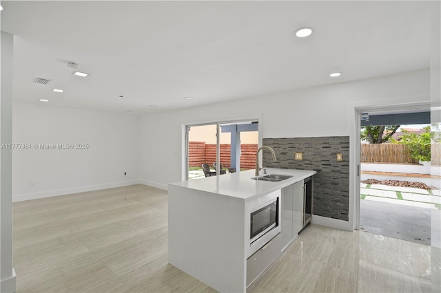 12894 SW 60th Ter, Miami, FL 33183 - kitchen with visible vents, modern cabinets, light countertops, stainless steel microwave, and a sink