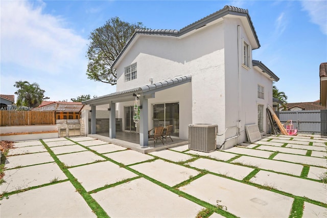 12894 SW 60th Ter, Miami, FL 33183 - back of house with a fenced backyard, a patio area, central air condition unit, and an outdoor kitchen