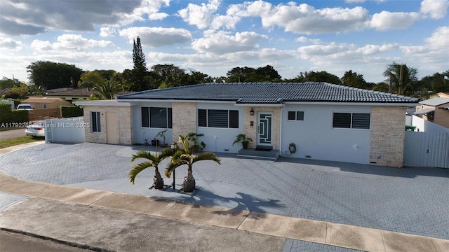 9365 SW 44th St, Miami, FL 33165 - single story home featuring a tiled roof, fence, stone siding, and stucco siding