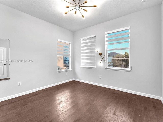 4317 Ficus St, Hollywood, FL 33021 - spare room featuring baseboards, a wealth of natural light, a notable chandelier, and dark wood-type flooring