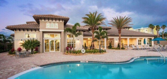 4317 Ficus St, Hollywood, FL 33021 - rear view of property featuring a patio, a community pool, stucco siding, and a tiled roof