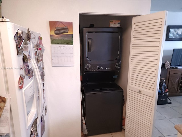 washroom with light tile patterned floors, laundry area, and stacked washer / dryer