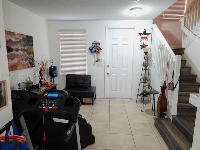 foyer featuring light tile patterned floors and stairway