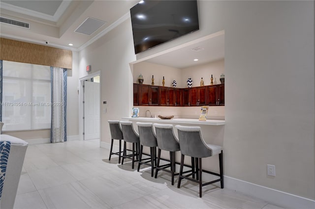 3064 SE 1st Dr Unit 3, Homestead, FL 33033 - kitchen featuring dark brown cabinets, a breakfast bar, light countertops, ornamental molding, and recessed lighting