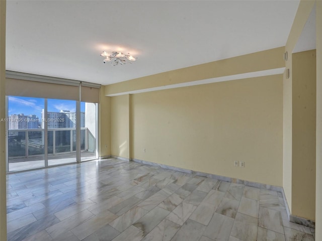 unfurnished room featuring baseboards and a city view