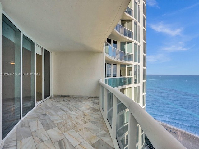 balcony featuring a beach view and a water view