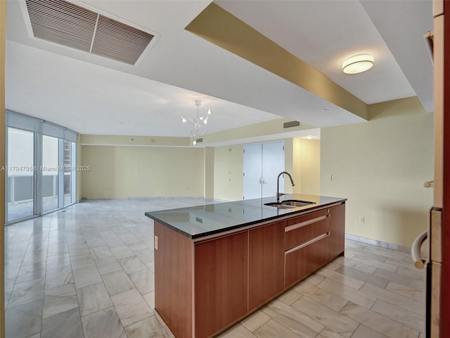17201 Collins Ave Unit 1704, Sunny Isles Beach, FL 33160 - kitchen featuring visible vents, dark countertops, a center island with sink, a sink, and open floor plan