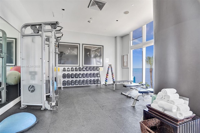 exercise room featuring a water view and visible vents