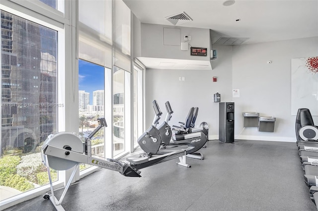 exercise room featuring baseboards, a city view, and visible vents