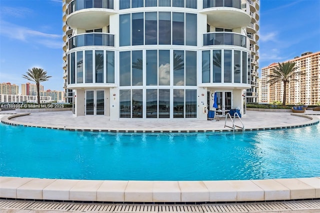 pool with a view of city and a patio area