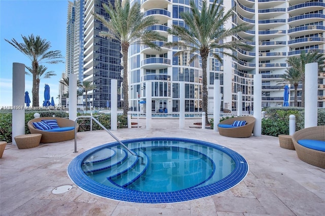 view of swimming pool with a hot tub and a patio area