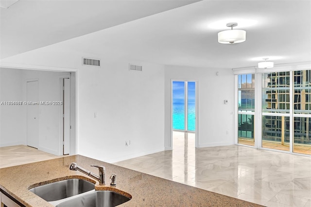 kitchen with visible vents, a sink, and light stone countertops