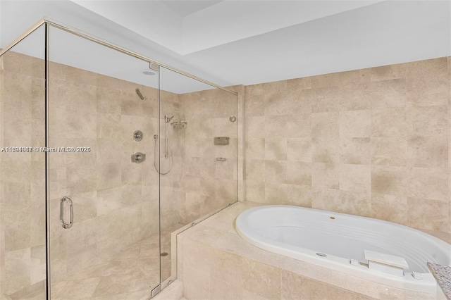 bathroom with a shower stall and a bath
