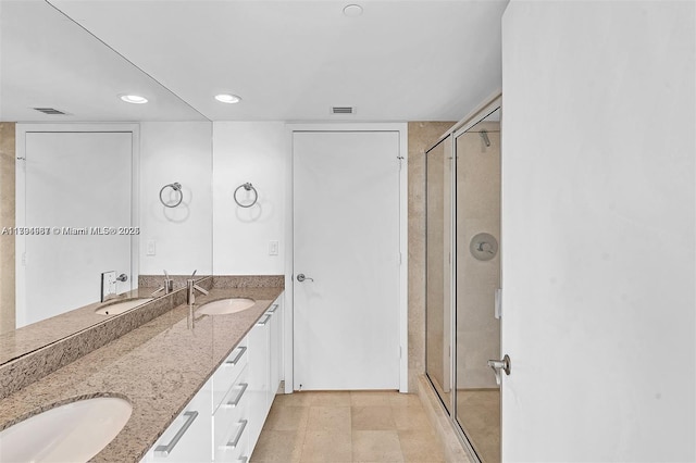 bathroom with double vanity, recessed lighting, a shower stall, and a sink