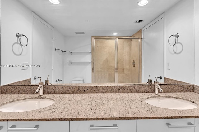 full bath with a sink, a shower stall, and recessed lighting