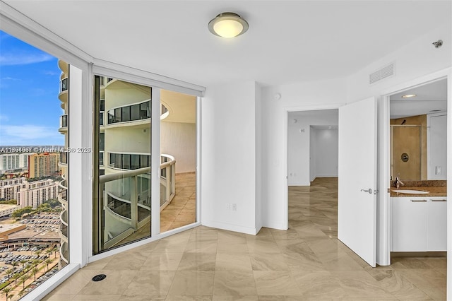 interior space with visible vents, a sink, baseboards, and expansive windows