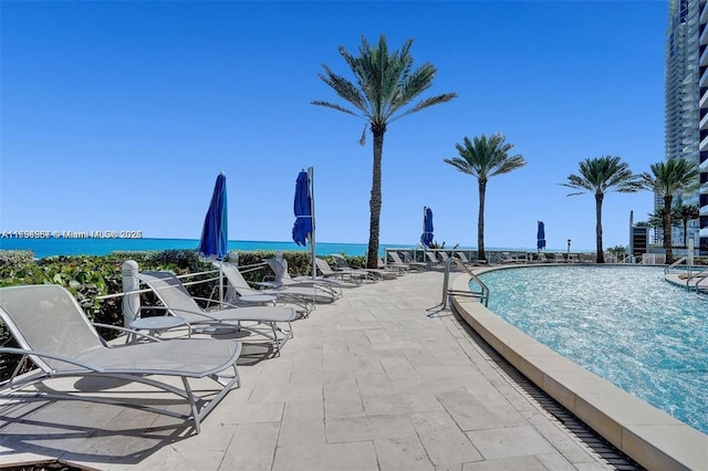 community pool featuring a water view and a patio area
