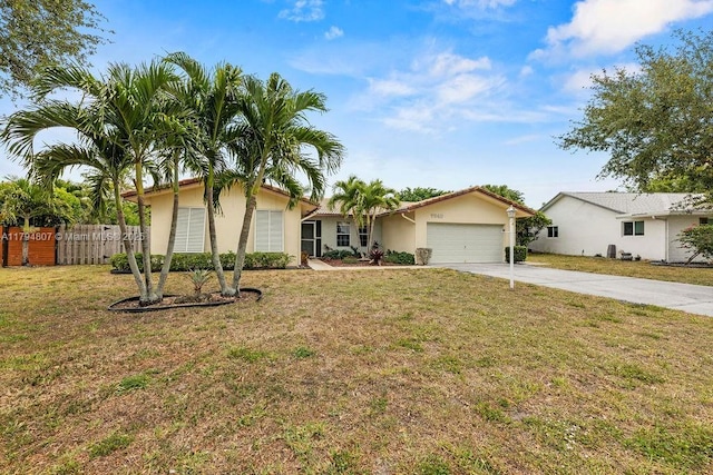 view of front of house with fence, an attached garage, concrete driveway, stucco siding, and a front yard