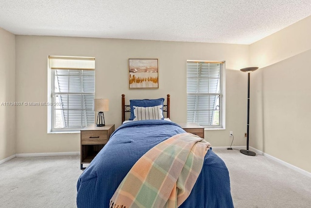 bedroom featuring a textured ceiling, carpet floors, and baseboards
