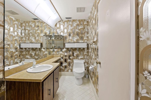 bathroom with wallpapered walls, toilet, visible vents, tile patterned floors, and vanity