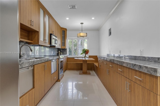 549 NE 12th Ave, Fort Lauderdale, FL 33301 - kitchen featuring visible vents, tasteful backsplash, a sink, appliances with stainless steel finishes, and light tile patterned floors
