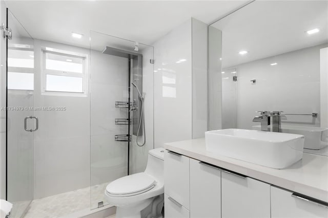 full bath with vanity, toilet, and a stall shower