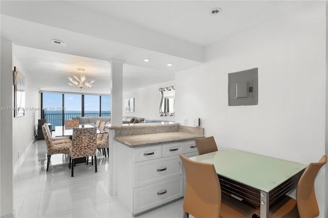 dining area with a chandelier, recessed lighting, light tile patterned floors, a water view, and electric panel