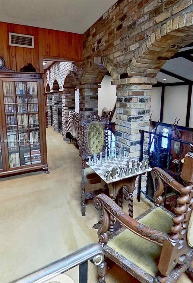 dining room featuring wooden walls, arched walkways, and visible vents