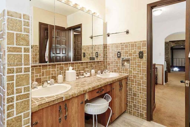 bathroom featuring double vanity, wainscoting, and a sink