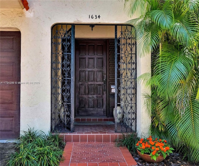 doorway to property featuring stucco siding
