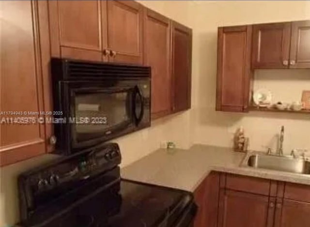 kitchen with light countertops, brown cabinetry, a sink, and black appliances