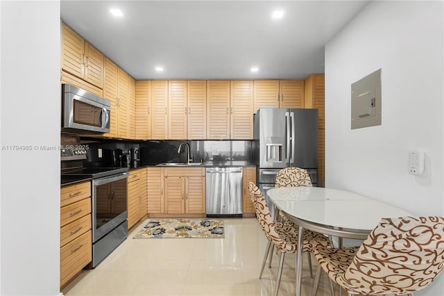 kitchen with a sink, stainless steel appliances, recessed lighting, backsplash, and electric panel
