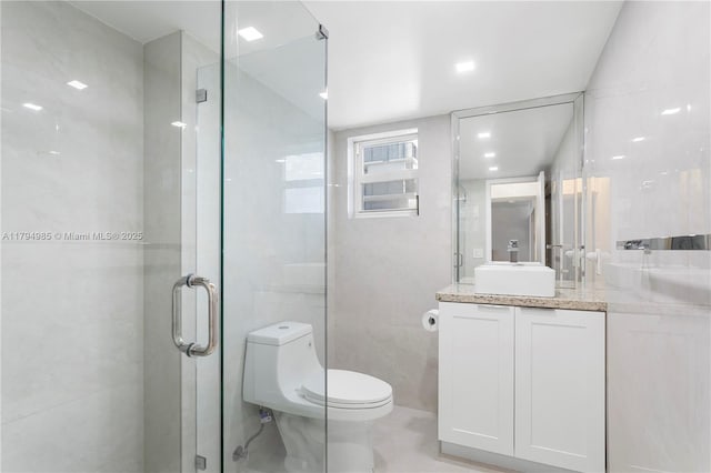 bathroom featuring vanity, toilet, and a stall shower