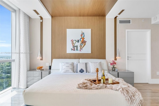 17111 Biscayne Blvd Unit 2208, Aventura, FL 33160 - bedroom featuring light wood-style floors, wooden ceiling, wooden walls, and visible vents