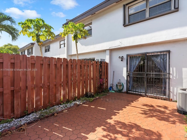 8000 SW 152nd Ave Unit 111, Miami, FL 33193 - view of property exterior featuring fence, stucco siding, cooling unit, and a patio area
