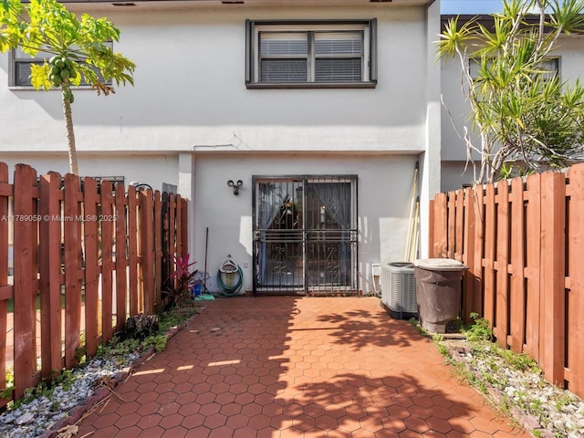 8000 SW 152nd Ave Unit 111, Miami, FL 33193 - view of front of house with central air condition unit, fence private yard, a patio area, and stucco siding