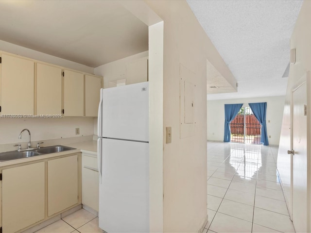 8000 SW 152nd Ave Unit 111, Miami, FL 33193 - kitchen featuring cream cabinets, a sink, light tile patterned floors, freestanding refrigerator, and open floor plan