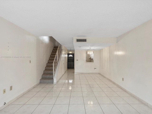 8000 SW 152nd Ave Unit 111, Miami, FL 33193 - unfurnished living room featuring visible vents, light tile patterned floors, a notable chandelier, and stairway